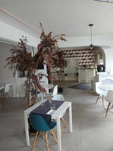 a dining room with a white table and chairs at Aux Vendanges de Bourgogne in Paray-le-Monial