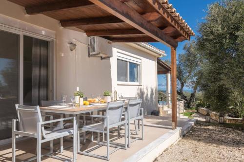 a patio with a table and chairs under a pergola at Villa Gisele with Private Pool in Tragaki