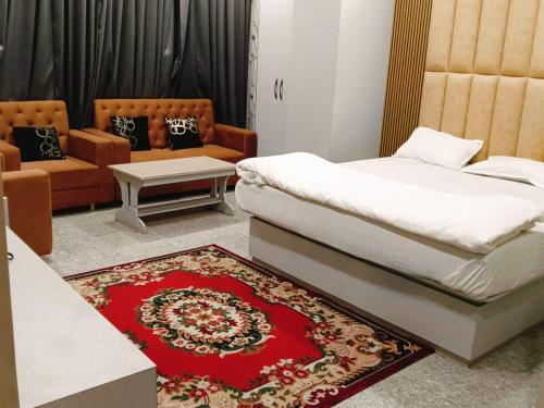 ein Schlafzimmer mit einem Bett, einem Teppich und einem Sofa in der Unterkunft Hotel Ganesha - residential in Muzaffarpur