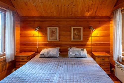 a bedroom with a bed in a wooden room at Mökki Aapola in Puumala