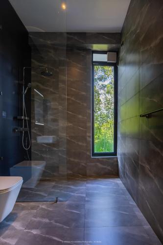 a bathroom with a shower and a sink and a window at Namara Green Ella in Ella