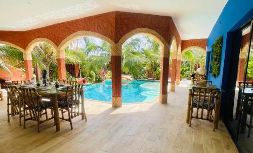 een eetkamer met een tafel en een zwembad bij Téranga paradis in Somone