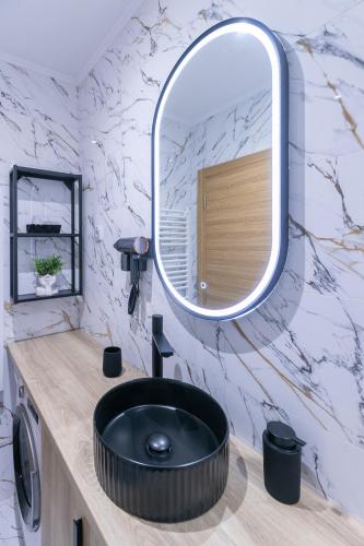 a bathroom with a black sink and a mirror at Royal Crown Apartments in Subotica