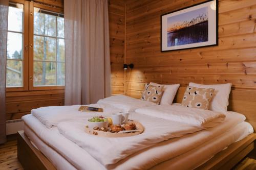 a large bed with a tray of food on it at Matilda Villas, quality villas by the sea in the beautiful village of Mathildedal in Matildedal
