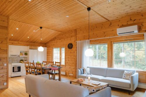 a living room with a couch and a table at Matilda Villas, quality villas by the sea in the beautiful village of Mathildedal in Matildedal