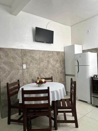 a kitchen with a table with chairs and a refrigerator at Casas do Matteo - 2ª Praia in Morro de São Paulo
