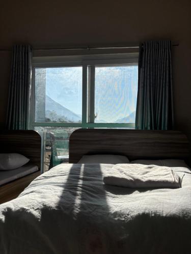 a bedroom with a bed and a large window at Gauthali Inn in Netadurling