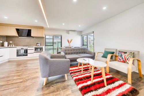 a living room with a couch and two chairs and a table at Cosy & Contemporary entire 3 Bedroom Airport Retreat in Auckland