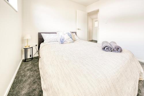 a white bedroom with a large bed in a room at Cosy & Contemporary entire 3 Bedroom Airport Retreat in Auckland