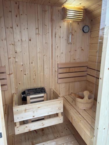 een houten sauna met een klok aan de muur bij Rebe 11 - Moderne Ferienwohnung mit Sauna in Oestrich-Winkel