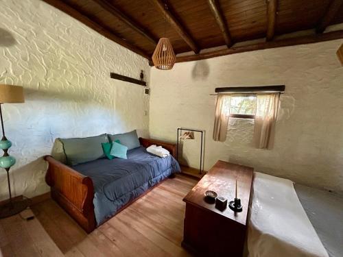 a bedroom with a bed and a table in a room at Iris,Tiny house en Las Calles, Traslasierra in Las Calles