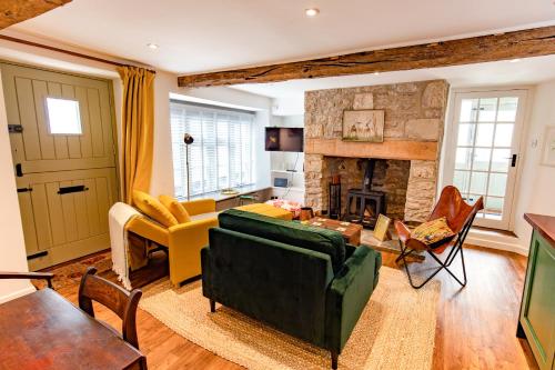 a living room with a green couch and a fireplace at A Hidden Gem in the Heart of Wells, Somerset in Wells
