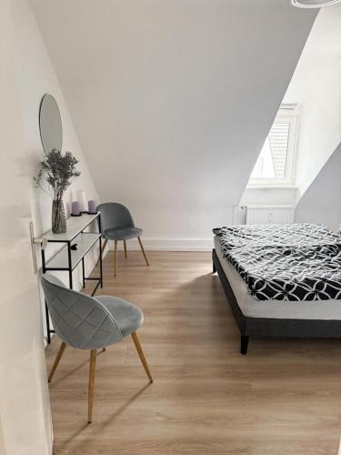 a bedroom with a bed and a chair and a mirror at Gemütliche Wohnung über den Dächern von Gevelsberg in Gevelsberg
