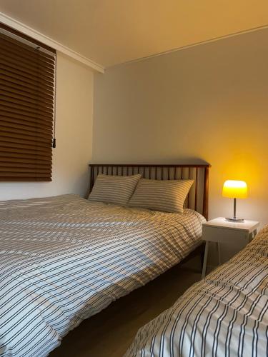 a bedroom with two beds and a lamp on a table at 스테이아지트 in Seoul