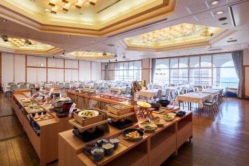 a dining room with tables with food on them at Hotel New Tsuruta in Beppu