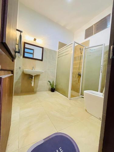a bathroom with a shower and a sink and a toilet at New Lavan Bolgoda in Piliyandala
