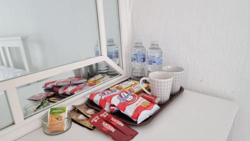 a shelf in a refrigerator with snacks and water bottles at CityStay London in London