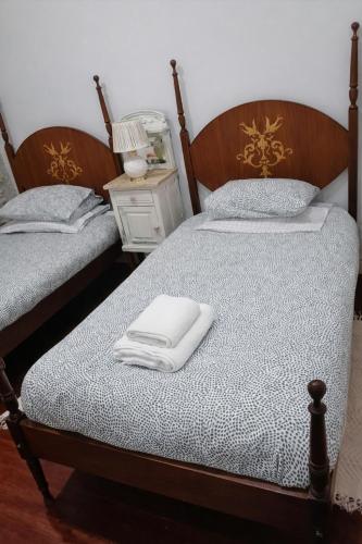 two beds with white towels on them in a room at Nature House Lagos do Sabor in Torre de Moncorvo