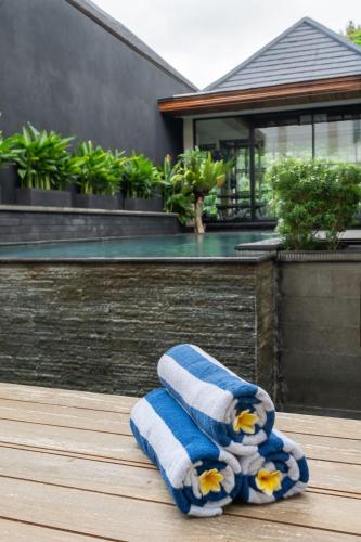 a blue and white towel sitting on a deck at Aresty 3 Bedroom Villa Canggu in Canggu