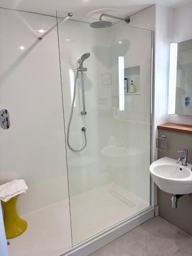 a bathroom with a shower and a sink at Regatta - A lakeview apartment in Thorpeness - Aldeburgh Coastal Cottages in Thorpeness