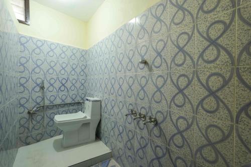 a bathroom with a toilet and a swirl pattern on the wall at Ashu Homestay Nest 1 in Pondicherry