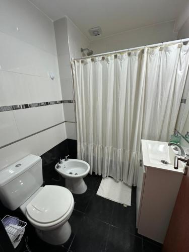 a white bathroom with a toilet and a sink at Dpto 9 - Colon - 1 DORMITORIO - PQ ALQUILERES TEMPORARIOS in Colón