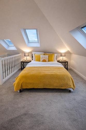 a bedroom with a bed with a yellow blanket at Beautiful cosy attic studio flat king size bed in central Beeston in Nottingham in Beeston