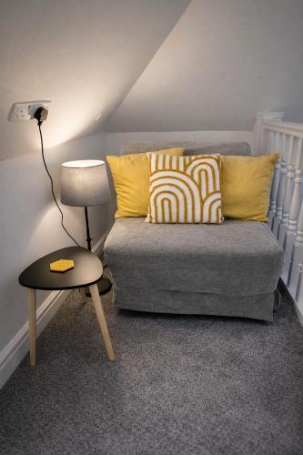 a living room with a couch and a table at Beautiful cosy attic studio flat king size bed in central Beeston in Nottingham in Beeston