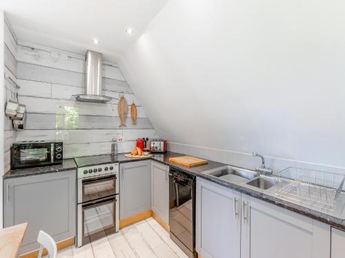 a kitchen with white cabinets and a sink at Valley Lodge - Uk49228 in Gunnislake