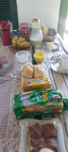 a table with food on it with bananas and other foods at Hostel33 brazil praia in Caraguatatuba