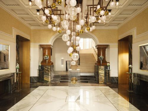eine große Lobby mit einem großen Kronleuchter und einer Treppe in der Unterkunft Mandarin Oriental, Vienna in Wien