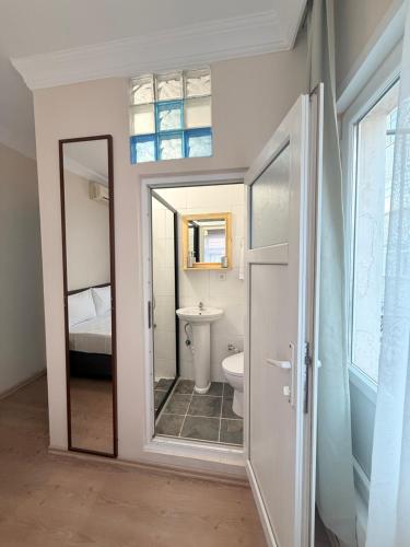 a bathroom with a toilet and a sink and a mirror at walkabout apart in Istanbul