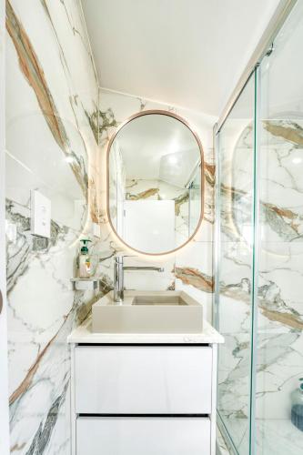a bathroom with a sink and a mirror at Elegant & Peaceful in Auckland Vicinity in Auckland