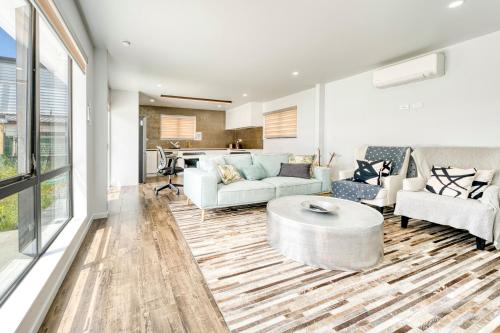 a living room with two couches and a table at Elegant & Peaceful in Auckland Vicinity in Auckland