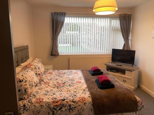 een slaapkamer met een bed en een flatscreen-tv bij Light and airy cosy bungalow in Draycott