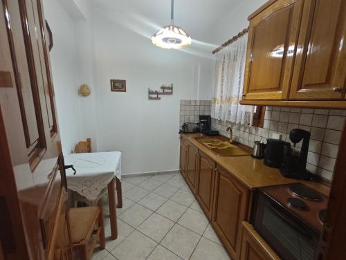 una cucina con mobili in legno e un piano di lavoro di Avlonitis Rooms a Párga