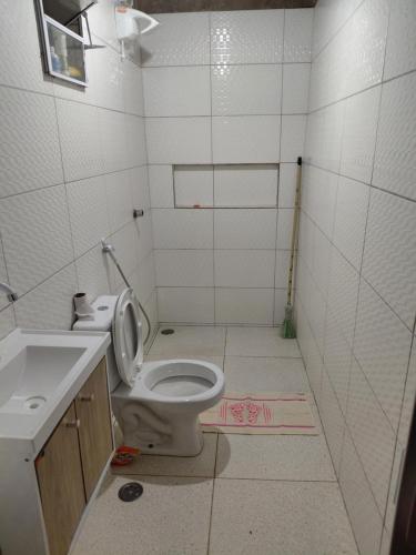 a bathroom with a toilet and a sink at Casa Praça in Paripueira