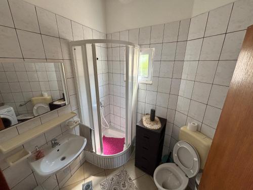 a bathroom with a shower and a toilet and a sink at Apartmani Kežić Drvenik in Drvenik