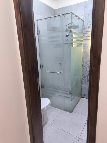 a bathroom with a toilet and a glass shower at la Hacienda Cozy Studio Chalet in Ras Sedr