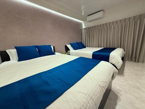 two beds in a room with blue and white at Ray House in Yokohama