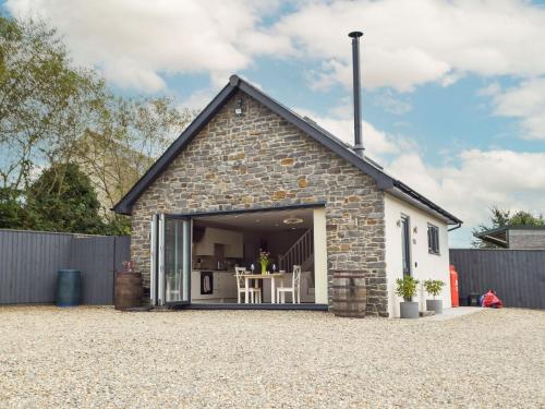 a small brick house with a large sliding glass door at Brook View Cottage in Pembrokeshire