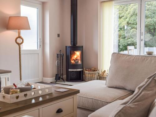 a living room with a couch and a fire place at Brook View Cottage in Pembrokeshire