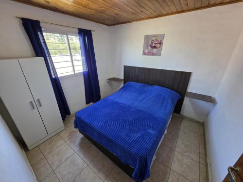 a small bedroom with a bed with a blue blanket at Complejo Balcarce in San Rafael
