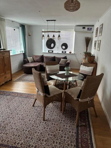a living room with a couch and a table and chairs at Gästewohnung Karin in Fjelby