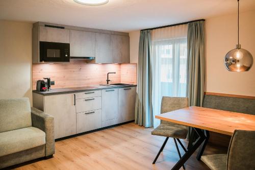 una cucina e una sala da pranzo con tavolo e sedie di die Harmonie a Nauders