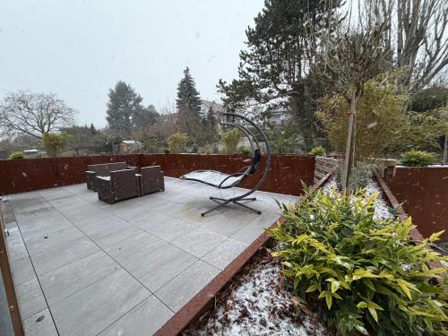 eine Holzterrasse mit Stuhl und Schaukel in der Unterkunft Le chalet O'Perché - Wissembourg in Wissembourg