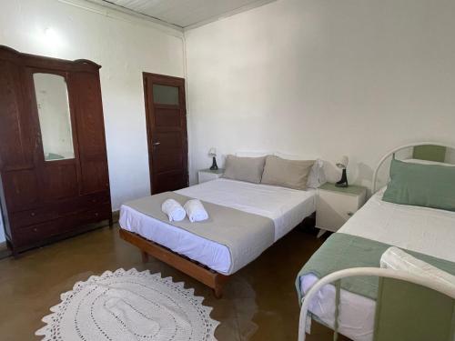 una camera con due letti con lenzuola bianche e una porta di Catalina House ad Alta Gracia