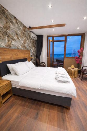 a bedroom with a large bed and a large window at Goga Otel in Sarıyer