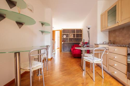 eine Küche und ein Wohnzimmer mit Tisch und Stühlen in der Unterkunft Centrale con panorama. in Siena