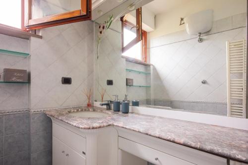 ein Badezimmer mit Waschbecken und Spiegel in der Unterkunft Centrale con panorama. in Siena